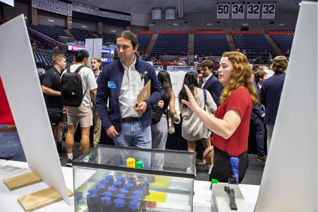senior design female student  explaining her project to a male spectator